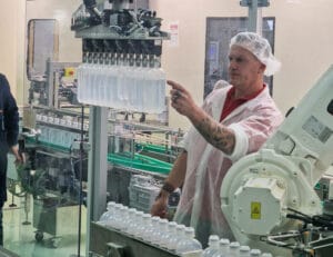 Radnik u farmaceutskoj proizvodnji proverava rad automatske linije za punjenje bočica