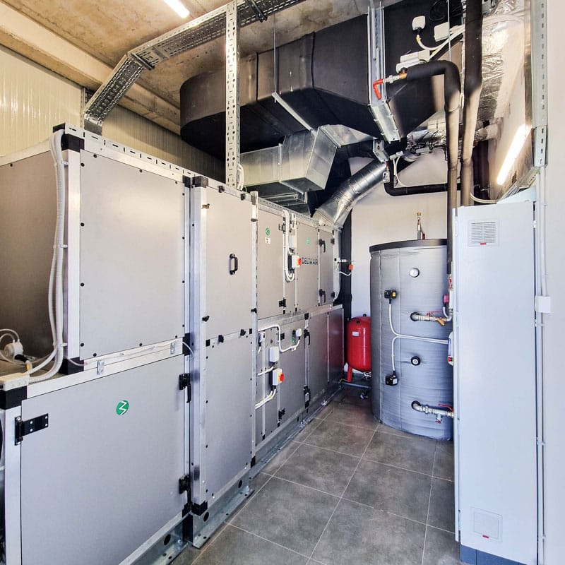 Tehnička prostorija sa ventilacionom jedinicom, toplovodnim bojlerom i izolovanim cevovodom za HVAC sistem