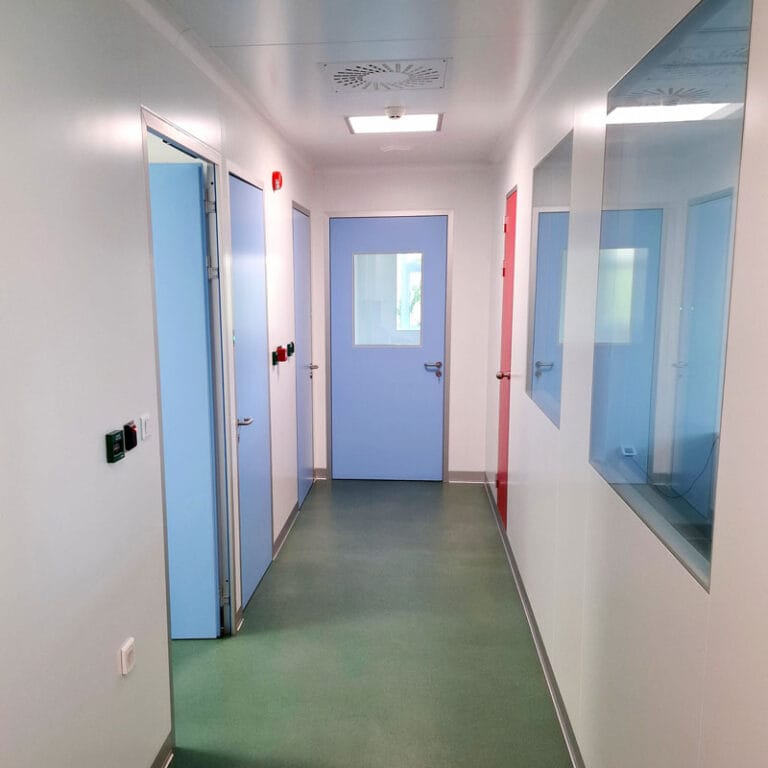 Sterilni hodnik u čistoj sobi sa plavim hermetičkim vratima, PVC podom i plafonskim difuzorom za ventilaciju