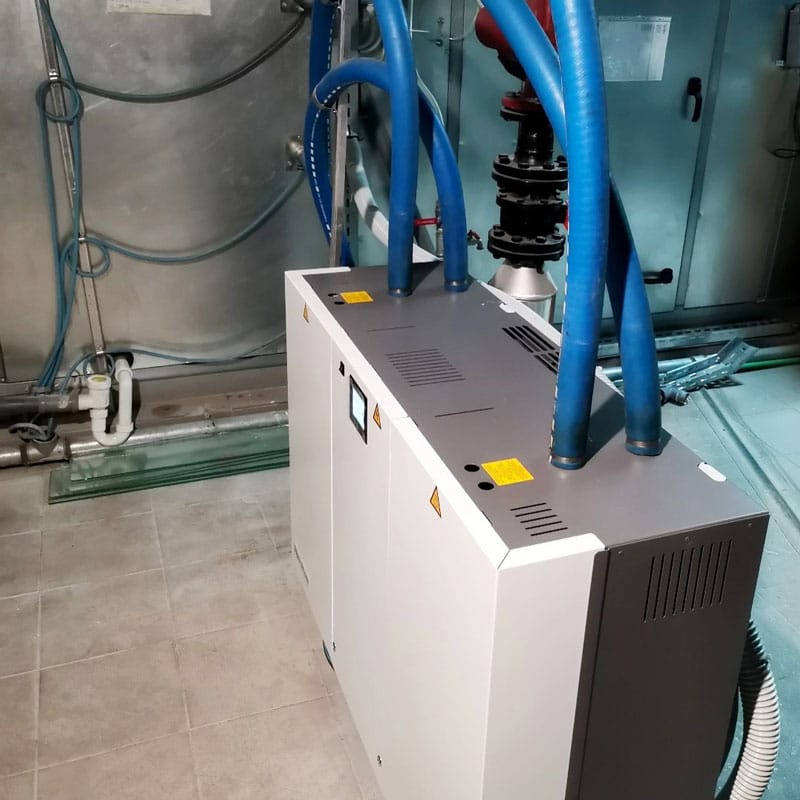 Električni ovlaživač vazduha integrisan u HVAC instalaciju, sa više priključenih plavih creva za distribuciju pare.