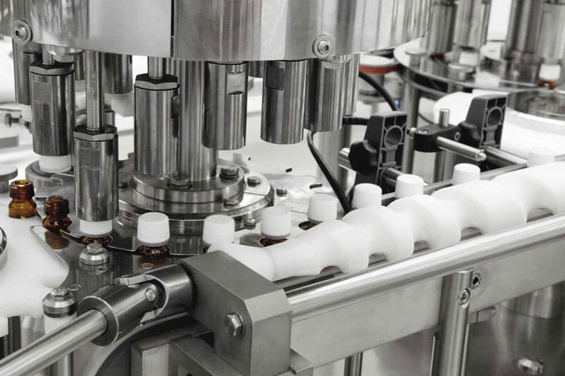 Automatska Comas mašina za zatvaranje farmaceutskih bočica sa višeglava rotacionom stanicom i vođenjem pomoću pužnog transportera.